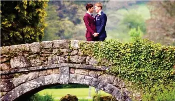  ??  ?? Bliss: Tom Daley and Dustin Lance Black embrace on a bridge in Burberry suits