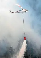  ?? NED DAWSON ?? Alan Beck’s helicopter helps douse the flames.