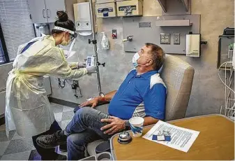  ?? Elizabeth Flores / Tribune News Service ?? Infusion Therapy Center nurse Heidi Leibold administer­s treatment to COVID-19 patient Jay Clark earlier this month at Mayo Family Clinic Northwest in Rochester, Minn.