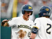  ?? Nati Harnik / Associated Press ?? Michigan’s Jimmy Kerr, left, celebrates after his two-run triple in the third inning helped propel the Wolverines to a 5-3 victory over Texas Tech.