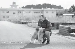  ?? KOTA ENDO/KYODO NEWS ?? Yoichi Yatsuda plays with his dogs Thursday at his home in Futaba, Japan. Until recently, the town has been deserted following a series of disasters in 2011.
