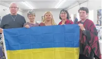  ?? ?? Homer Noble, left, Donna Pittman, Tetiana Piskun, Darlene Eisner and Rev. Valerie Taylor, minister of Torbrook Mines United Church, hold a Ukrainian flag at a yard sale to raise money for humanitari­an relief in Ukraine.