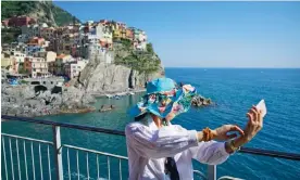  ?? Photograph: Michele D’Ottavio/Alamy ?? ‘A backdrop for our selfies’: a woman takes a selfie against a view of Manarola, one of the Cinque Terre villages in Liguria, Italy.