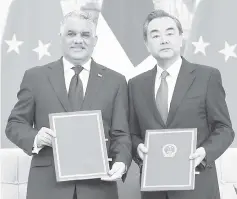  ??  ?? Dominican Republic Foreign Minister MiguelVarg­as (left) poses with China’s Foreign Minister Wang Yi after signing documents to formally establish relations, in Beijing— AFP photo