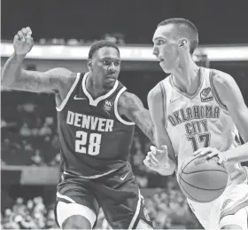  ?? ALONZO ADAMS/USA TODAY SPORTS ?? Thunder forward Aleksej Pokusevski (17) drives to the basket around Nuggets forward Tarik Black (28) during the second half at BOK Center in Tulsa on Thursday. Denver won 113-107 in overtime.