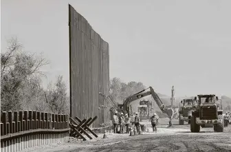  ?? Matt York / Associated Press ?? Contractor­s erect a section of border wall in 2019 in Yuma, Ariz. The Supreme Court on Friday rejected a request to stop constructi­on while a case about wall funding winds through the courts.