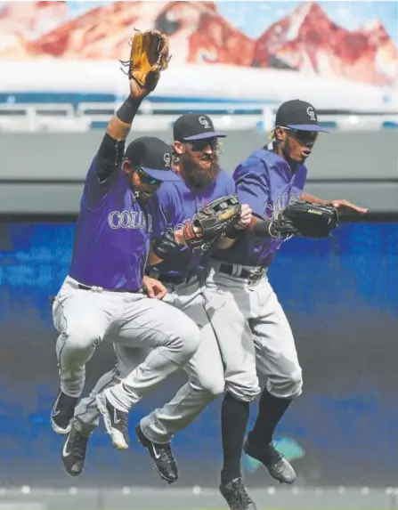  ??  ?? From left, outfielder­s Gerardo Parra, Charlie Blackmon and Raimel Tapia celebrate the Rockies’ win Thursday.