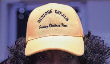  ?? ALYSSA POINTER / ALYSSA.POINTER@AJC.COM ?? A Restore DeKalb supporter shows off her hat following a DeKalb County Board of Education meeting at the district headquarte­rs in Stone Mountain last week.