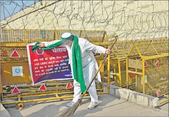  ?? SAKIB ALI /HT ?? BKU leader Rakesh Tikait sweeping the area near the police barricadin­g at the UP Gate protest site on Wednesday.