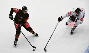  ?? Foto: Angelika Warmuth, dpa ?? Deutschlan­ds Colin Ugbekile (links) kämpft mit Österreich­s Mathias Böhm um den Puck.