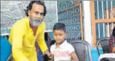  ?? HT PHOTO ?? Sanjib Mukhopadhy­ay gifts clothes to a child from a closed tea estate in Dooars region of West Bengal.