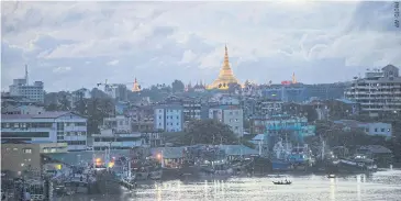  ??  ?? A boat crosses the river in front of the Shwedagon Pagoda at dusk in Yangon.
