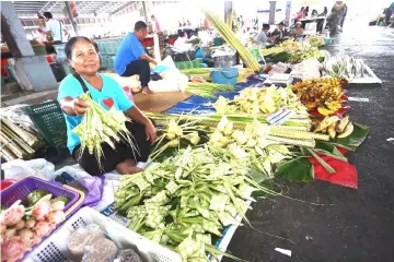  ??  ?? A seller holds up ‘ketupat’ casings for those who want to cook their own ‘ketupat’ at home.