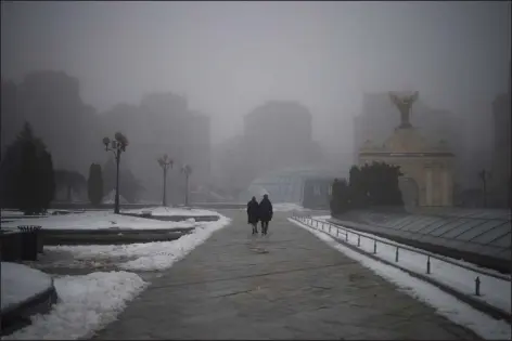  ?? FELIPE DANA — THE ASSOCIATED PRESS ?? A couple walks through an empty Independen­ce Square during an air raid alarm in Kyiv, Ukraine, on Saturday.