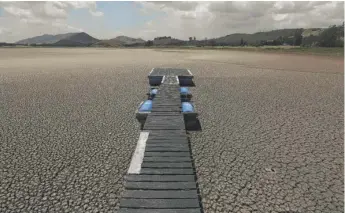  ?? FERNANDO VERGARA/AP ?? A floating dock sits on the lakebed of the Suesca lagoon in Suesca, Colombia. The lagoon has seen its water surface area decline radically due to years of severe droughts in the area.