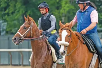  ?? AP PHOTO BY JOHN MINCHILLO ?? Kentucky Derby winner Rich Strike, left, walks off the track Thursday in Elmont, N.Y., after a training session for Saturday’s Belmont Stakes.