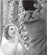  ?? Jenny Sparks, Loveland Reporter-Herald ?? Kristine Crummel watches as her newlywed husband attaches their lock to the Love Lock sculpture in Loveland on Feb. 1.