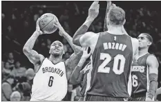  ??  ?? JOY RIDE: Sean Kilpatrick, who finished with 22 points, drives to the basket against Timofey Mozgov during the Nets’ 107-97 win over the Lakers. Brook Lopez (right) celebrates the victory.