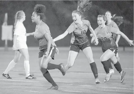  ?? KARL MERTON FERRON/BALTIMORE SUN ?? McDonogh’s Lilly McCarthy (10) and Kelsey Smith (20) celebrate behind forward Aria Bilal, who scored the first goal against Spalding.