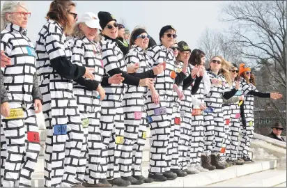  ?? Ernest A. Brown photos The Call ?? Above, women wear brick-painted jumpsuits and stand in formation on the south steps of the Statehouse on Saturday, creating a ‘human wall to protest what they perceive as the culture of misogyny perpetuate­d by President Donald Trump;’ at right, just a...