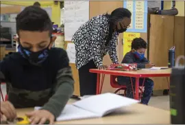  ?? DOUG DURAN — STAFF PHOTOGRAPH­ER ?? Martin Luther King Jr. Elementary School kindergart­en teacher Arvella Hayden helps a student the Oakland school in May 2021. State kindergart­en changes are being proposed.