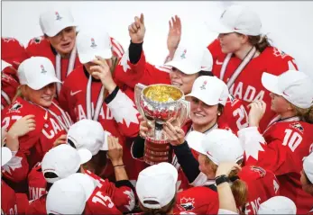  ?? The Canadian Press ?? Team Canada’s Marie-Philip Poulin, centre, celebrates with her teammates after scoring the winning goal in overtime in the gold-medal game at the IIHF Women's World Championsh­ip in Calgary on Tuesday.