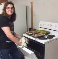  ??  ?? ■ Rowan Carter, son of owner Leesa Carter of The Gingerbrea­d House in Linden, has just removed some items from the oven. He’s a junior in Linden-Kildare High School.
