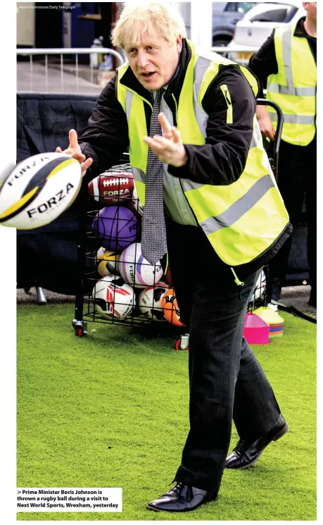  ?? Robin Formstone/Daily Telegraph ?? > Prime Minister Boris Johnson is thrown a rugby ball during a visit to Next World Sports, Wrexham, yesterday