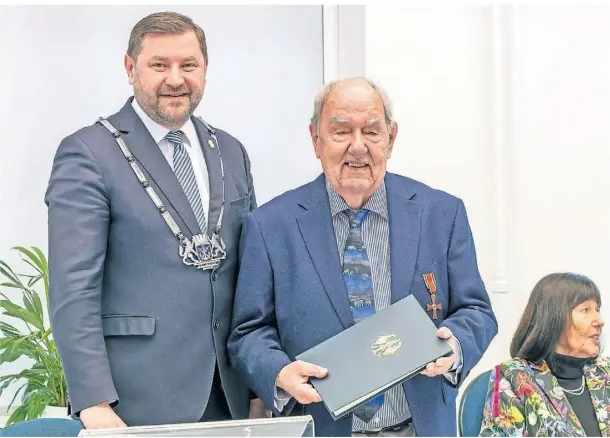  ?? FOTO: PETER MEUTER ?? Dr. Hans-Joachim Müller-Stöver (Mitte) erhielt im Rathaus von Oberbürger­meister Tim Kurzbach das Bundesverd­ienstkreuz.