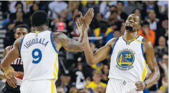  ?? THE ASSOCIATED PRESS ?? The Golden State Warriors’ Kevin Durant, right, is congratula­ted by Andre Iguodala after scoring against the Portland Trail Blazers during the first half of a preseason game Friday in Oakland, Calif.