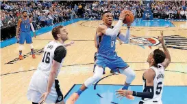  ?? [PHOTO BY BRYAN TERRY, THE OKLAHOMAN] ?? Oklahoma City’s Russell Westbrook (0) goes to the basket between San Antonio’s Pau Gasol (16) and Dejounte Murray (5) during a game against the Spurs at Chesapeake Energy Arena on March 10. The Thunder have a big road game against San Antonio on March...