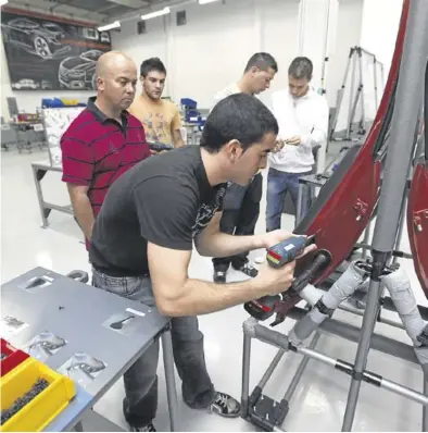  ?? JOSEP GARCÍA ?? Jóvenes en un curso de aprendizaj­e para parados que quieren incorporar­se al sector del automóvil.