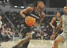  ?? ROGELIO V. SOLIS VIA AP ?? SOUTH CAROLINA GUARD ZACHARY DAVIS (12) starts to approach the basket while defended by Mississipp­i State guard Shakeel Moore (3) during the first half of a game on Saturday in Starkville, Miss.