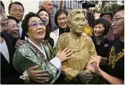  ??  ?? Continued focus: People moving in to take a closer look at the monument after it was unveiled in San Francisco. (Inset: Lee standing by a statue of activist Kim Hak-soon while looking at the monument. — AP