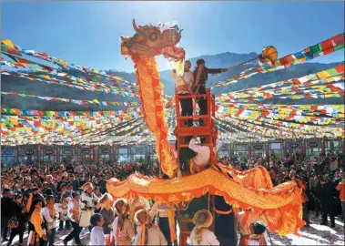  ?? JIANG HONGJING / XINHUA ?? People from the Tibetan ethnic group in Baoxing county, Sichuan province, perform an acrobatic dragon dance during Shangjiuji­e, a traditiona­l festival that honors the harvest of the past year and welcomes the new year. The festival is celebrated on the...