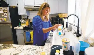  ?? NELVIN C. CEPEDA U-T PHOTOS ?? Ali Tebbs prepares her son Samuel’s formula at their home in Coronado. Samuel cannot take food orally so he relies on baby formula as his only source of nutrients.