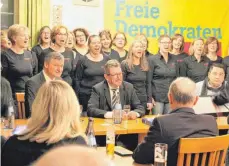  ?? FOTO: SIG ?? Mit dem Lied „Wunder gibt es immer wieder“, macht der Frauenchor Allegro FDP-Fraktionsc­hef Hans-Ulrich Rülke (links sitzend) beim Neujahrsem­pfang im „Bären“Mut. Rechts neben Rülke sitzt FDP-Kreisvorsi­tzender Hans-Ulrich Wetzel.