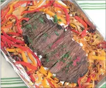  ?? PHOTOS BY CATHY THOMAS ?? First the peppers and onions are cooked in the sheet pan, then marinated flank steak is added.