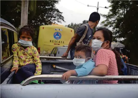  ?? (FABRICIO ALONZO/ANADOLU AGENCY/GETTY IMAGES) ?? Une famille fuit la zone de l’éruption dans la communauté de San Miguel Los Lotes, au sud de la capitale guatémaltè­que.