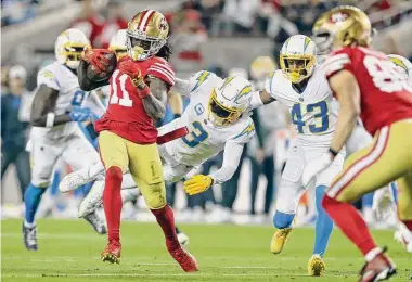  ?? Scott Strazzante/The Chronicle ?? Niners wide receiver Brandon Aiyuk runs after a catch while pursued by the Chargers’ Derwin James Jr. (3).