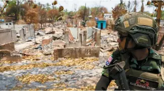  ?? Reuters-Yonhap ?? A soldier from the Karen National Liberation Army (KNLA) patrols on a vehicle, next to an area destroyed by Myanmar’s airstrike in Myawaddy, a Thailand-Myanmar border town under the control of a coalition of rebel forces led by the Karen National Union, April 15.