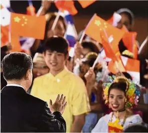  ?? — AFP ?? We welcome you: Xi (left) waving at children who were waiting to greet the Chinese president at the airport in Panama City.
