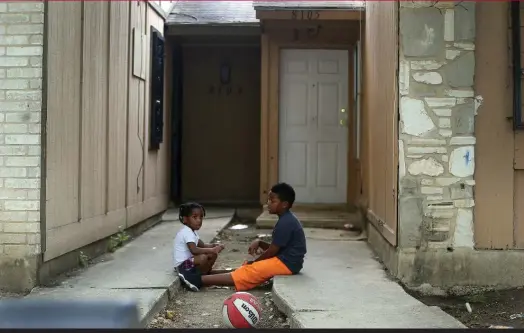  ?? JOHN DAVENPORT THE SAN ANTONIO EXPRESS-NEWS ?? Dozens of data points — gleaned from hospitals, schools, police and social workers — can indicate children’s risk for neglect and abuse. Here, kids play in front of a townhouse in San Antonio, Texas, where other children were kept chained in the back...