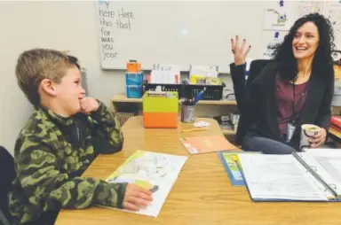  ??  ?? Cara Mentzel jokes with her student Ronan Miller during class at Foothill Elementary.