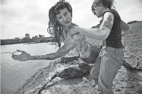  ?? KYLE KURLICK/SPECIAL TO THE COMMERCIAL APPEAL ?? March 18, 2011: Memphis College of Art graduate student Emily Stout installs life-size replicas of mermaids into the Wolf River on Mud Island across from the Pyramid as part of her MFA thesis. Stout’s piece is a look at public space and using mythologic­al creatures as a way of defying reason and the natural order of things.