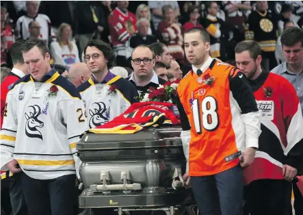  ?? LEAH HENNEL ?? Pallbearer­s at Lethbridge’s Nicholas Sheran Ice Centre carry the coffin of hockey player Brock Hirsche, who died of cancer, on Friday.