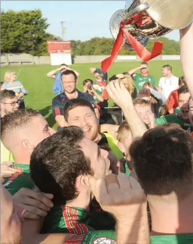  ??  ?? Stand-in Glen Emmets captain Ronan Grufferty holds the Christy Bellew Cup aloft at the Grove on Sunday.