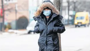 ?? REUTERS ?? A woman wears a mask in Chinatown following the outbreak of the novel coronaviru­s, in Chicago on Thursday.