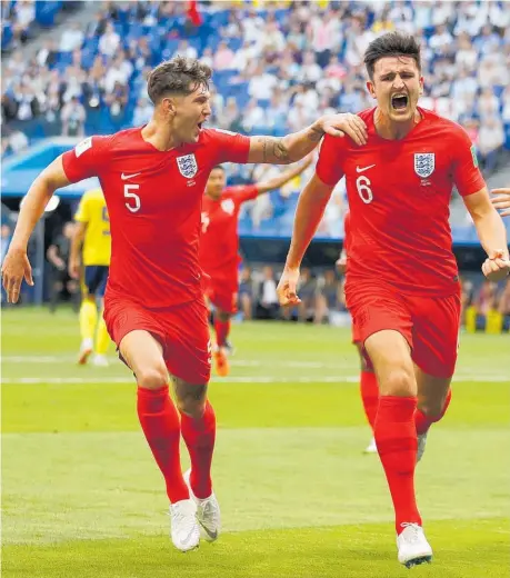  ??  ?? Harry Maguire celebrates with John Stones (left) and Harry Kane (right) after scoring his first goal for England yesterday.