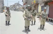  ?? — AFP ?? Paramilita­ry troopers stand guard during a curfew in downtown Srinagar on Friday.